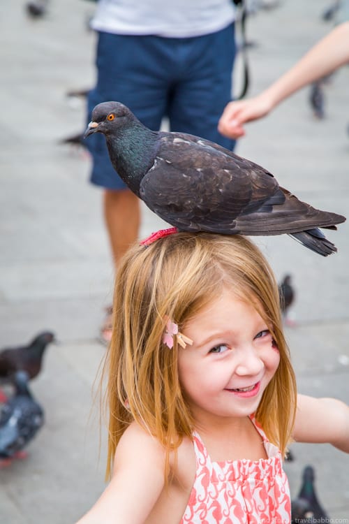 Venice with Kids - Enjoying the pigeons in St. Marks Square
