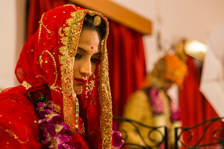 Indian Wedding - The bride, while the groom behind her is having his photo taken