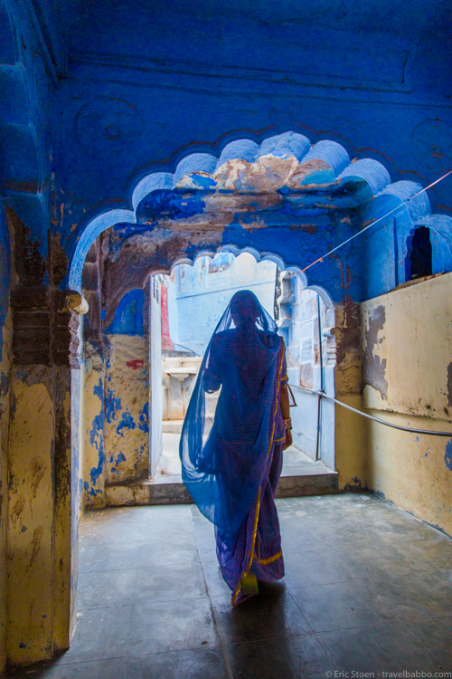 Places to visit in India - Jodhpur: A woman in blue walks through an archway the blue city