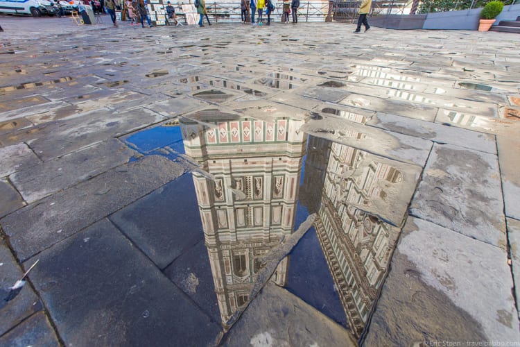 Travel Photography Tips - In Florence - the bell tower of the cathedral reflected in a small rain puddle
