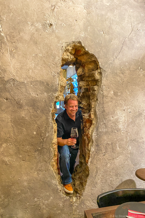 Florence restaurants - Note: if you can't get a table outside at Tamero, head inside. It's a fun restaurant, including this hole in the wall! My shirt is from Unbound Merino. 